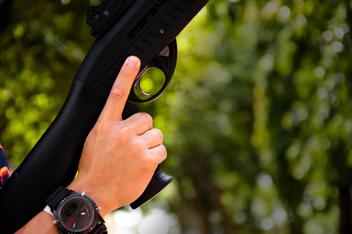 Asian young boy holds shotgun in hands, soft and selective focus on hands. photo