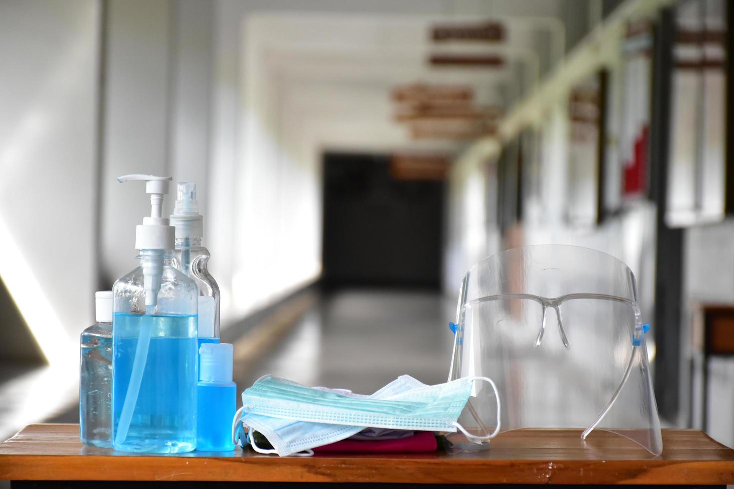 Covid 19 protective equipments on table, facemask, hand sanitizing gel, faceshield, alcohol gel, photo
