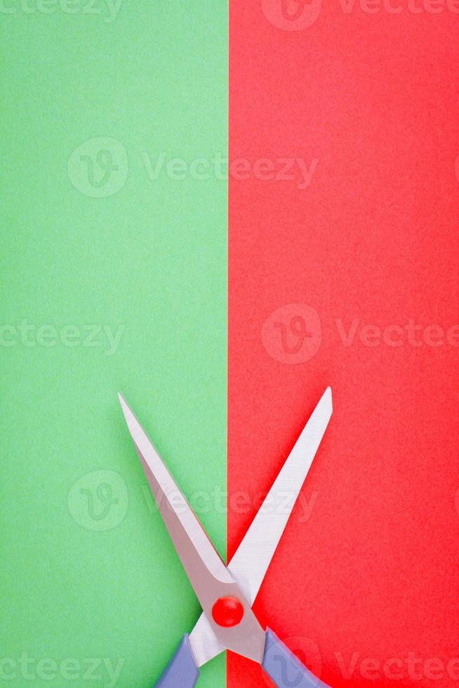 Minimalist image of scissors on red and green background. photo