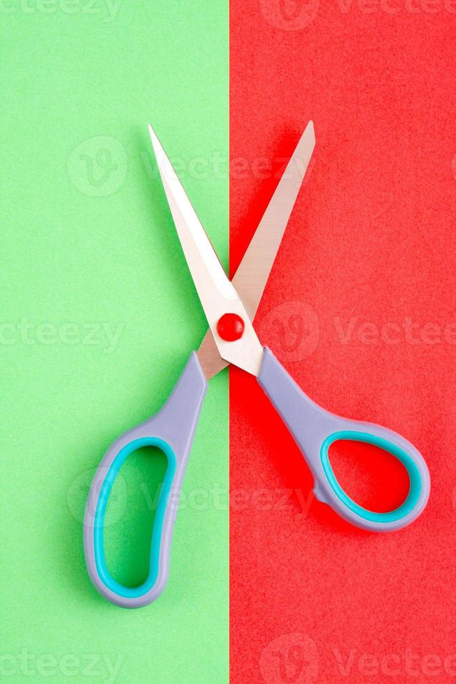 Minimalist image of scissors on red and green background. photo
