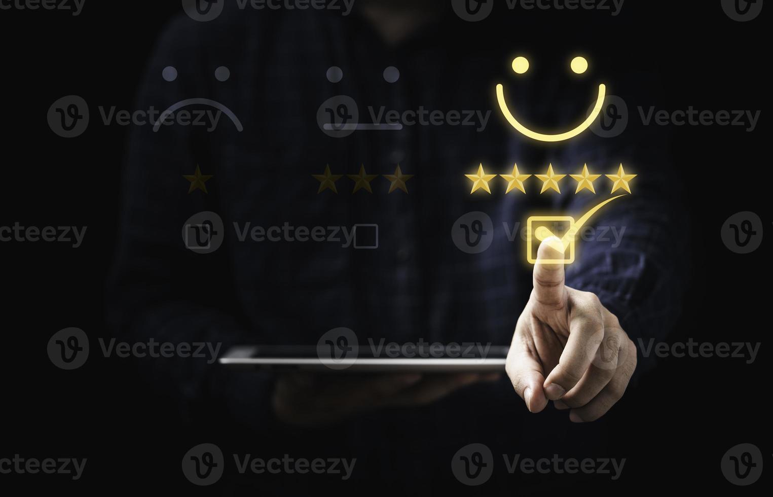Customer holding tablet and touching to tick sign on virtual smiley face for client evaluate after use product and service concept. photo