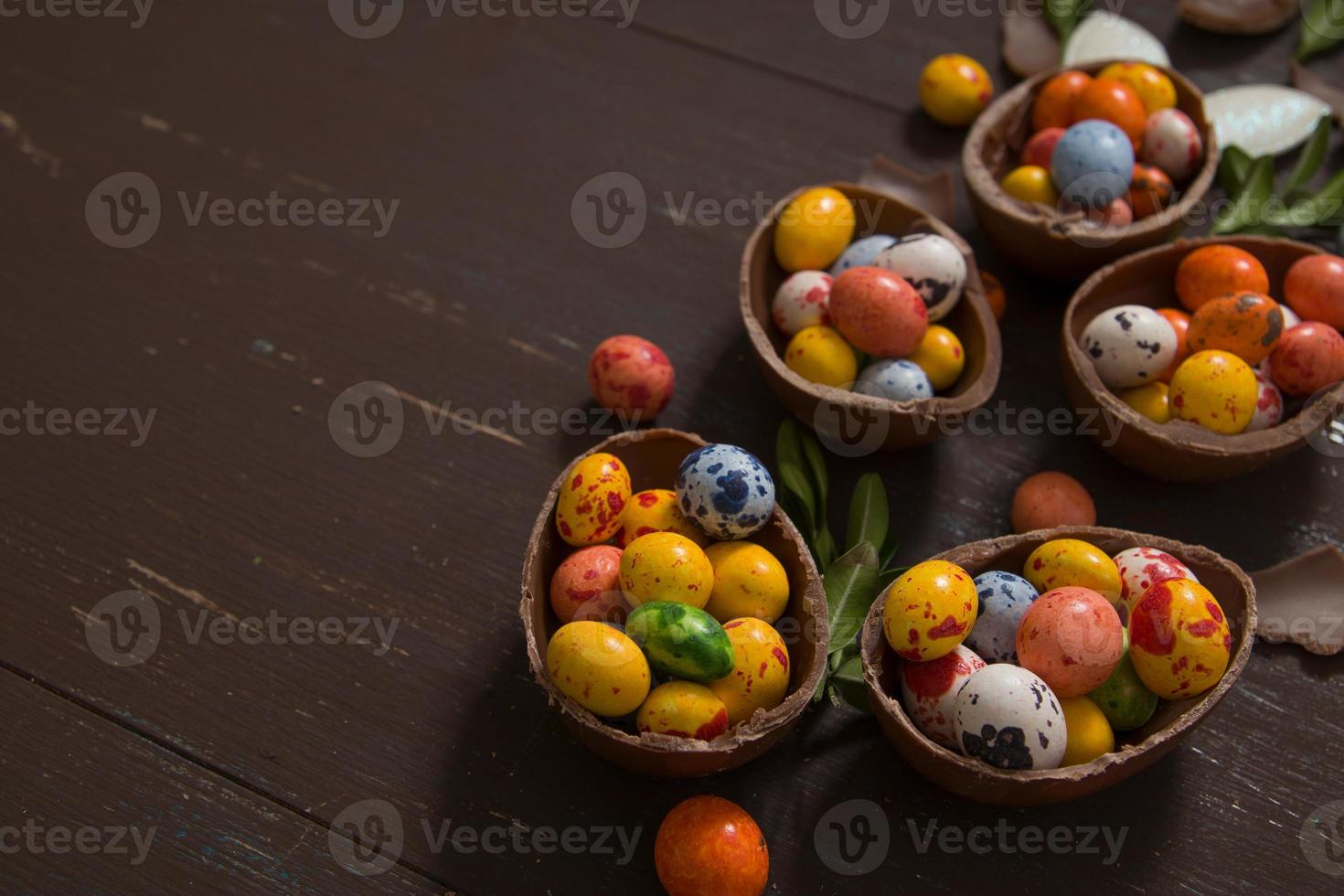 Easter hunt background with chocolate eggs on wooden backround copy space photo