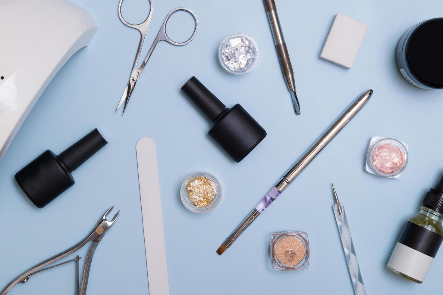 Top view of tools and materials for modern manicure and nail extension. Knolling on a blue background. Flat lay manicure tools photo