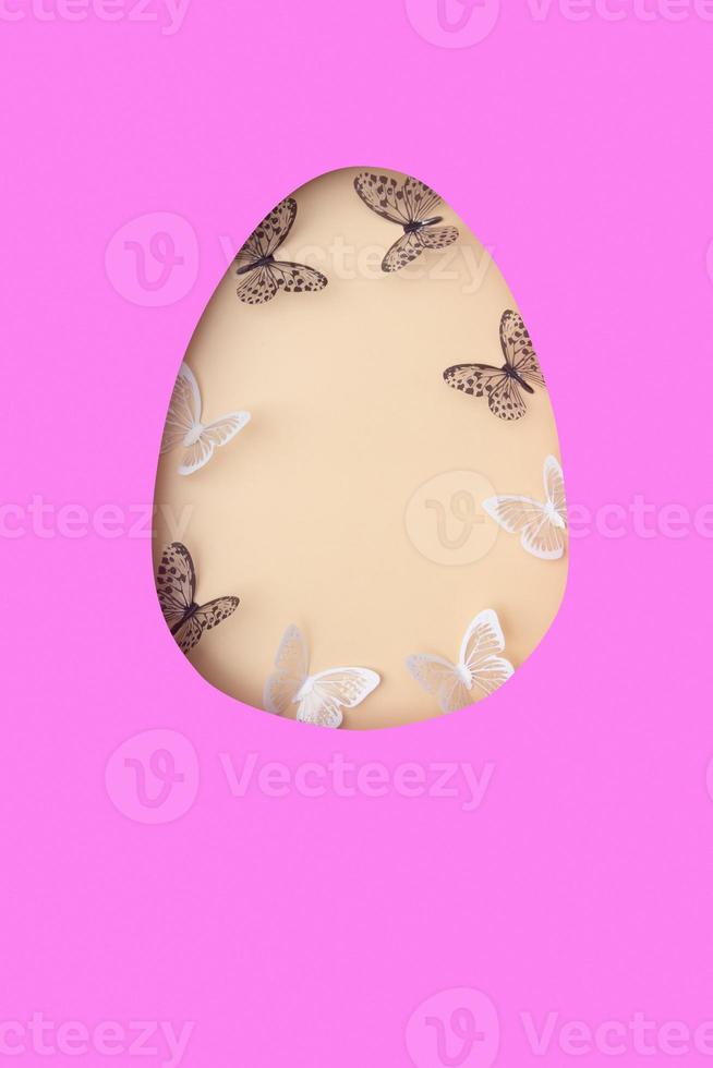 Easter egg cut out of paper and butterflies. Creative Easter holiday concept with copy space photo