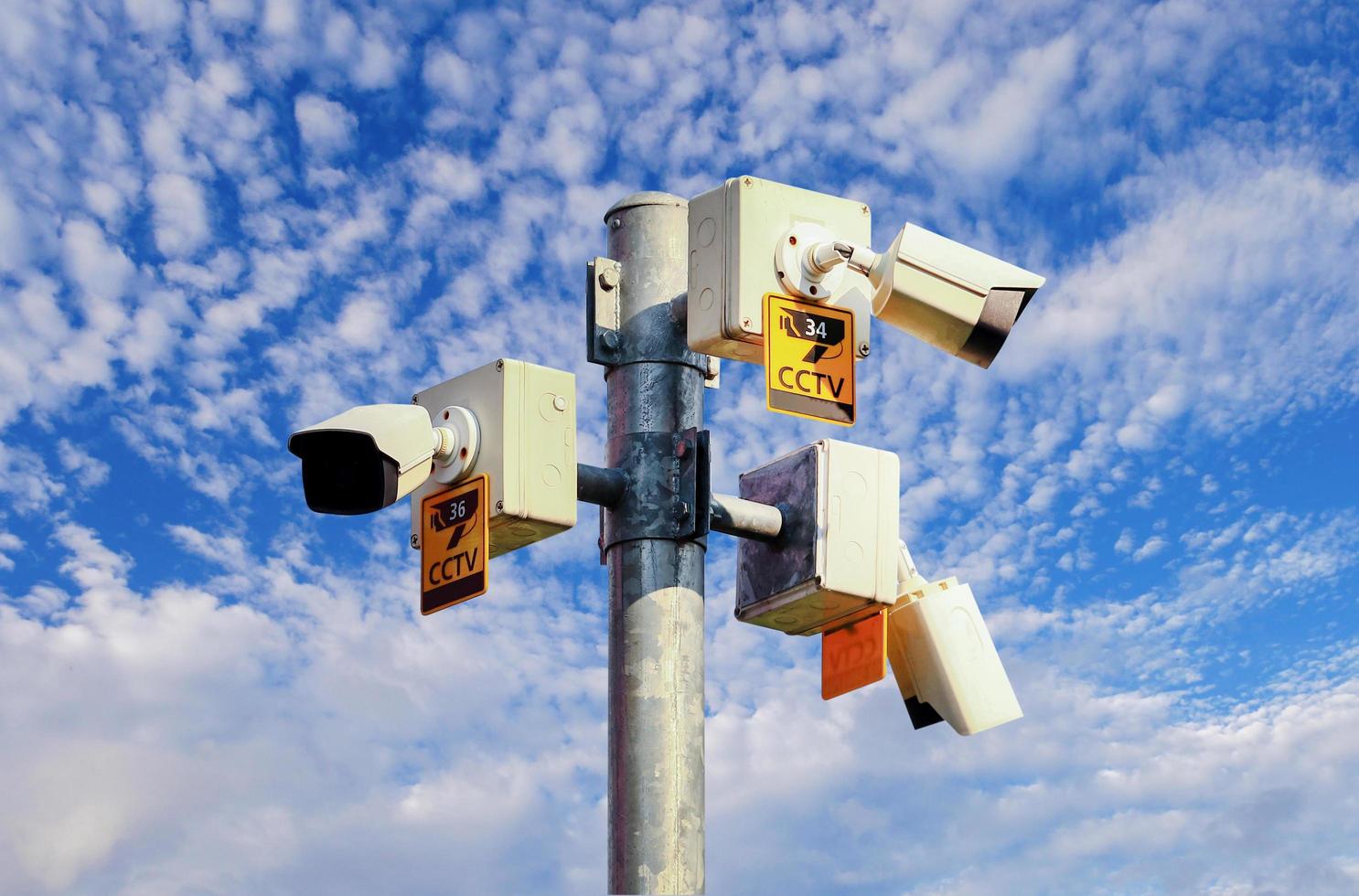 CCTV camera on bright blue sky background,  Concept. 24 hour day and night security photo