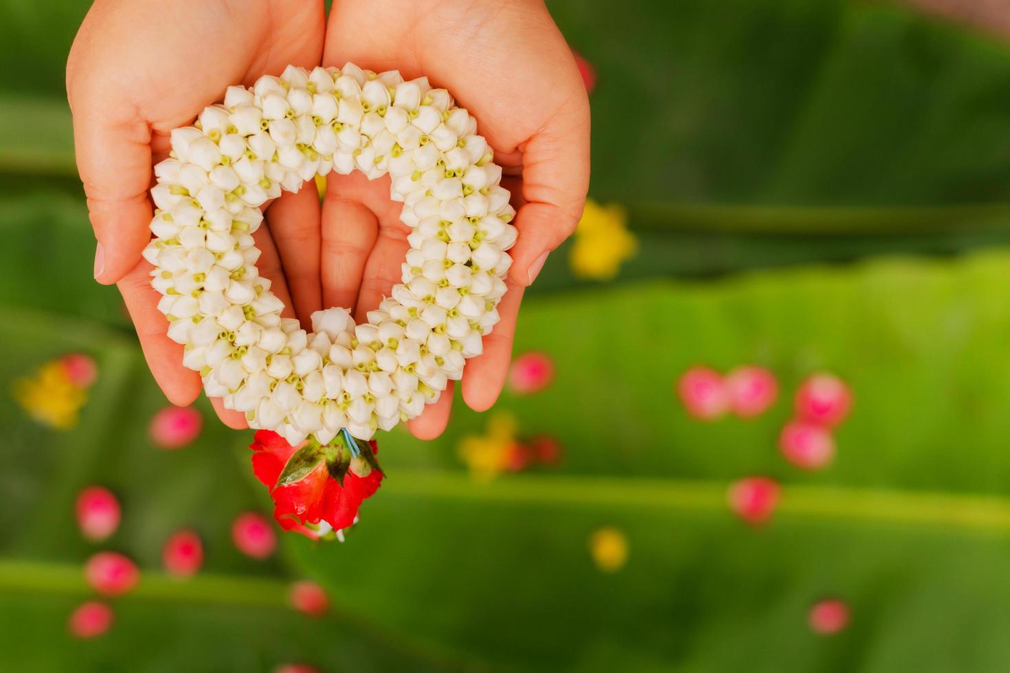 Mother's hand holding a jasmine garland during Songkran Festival photo