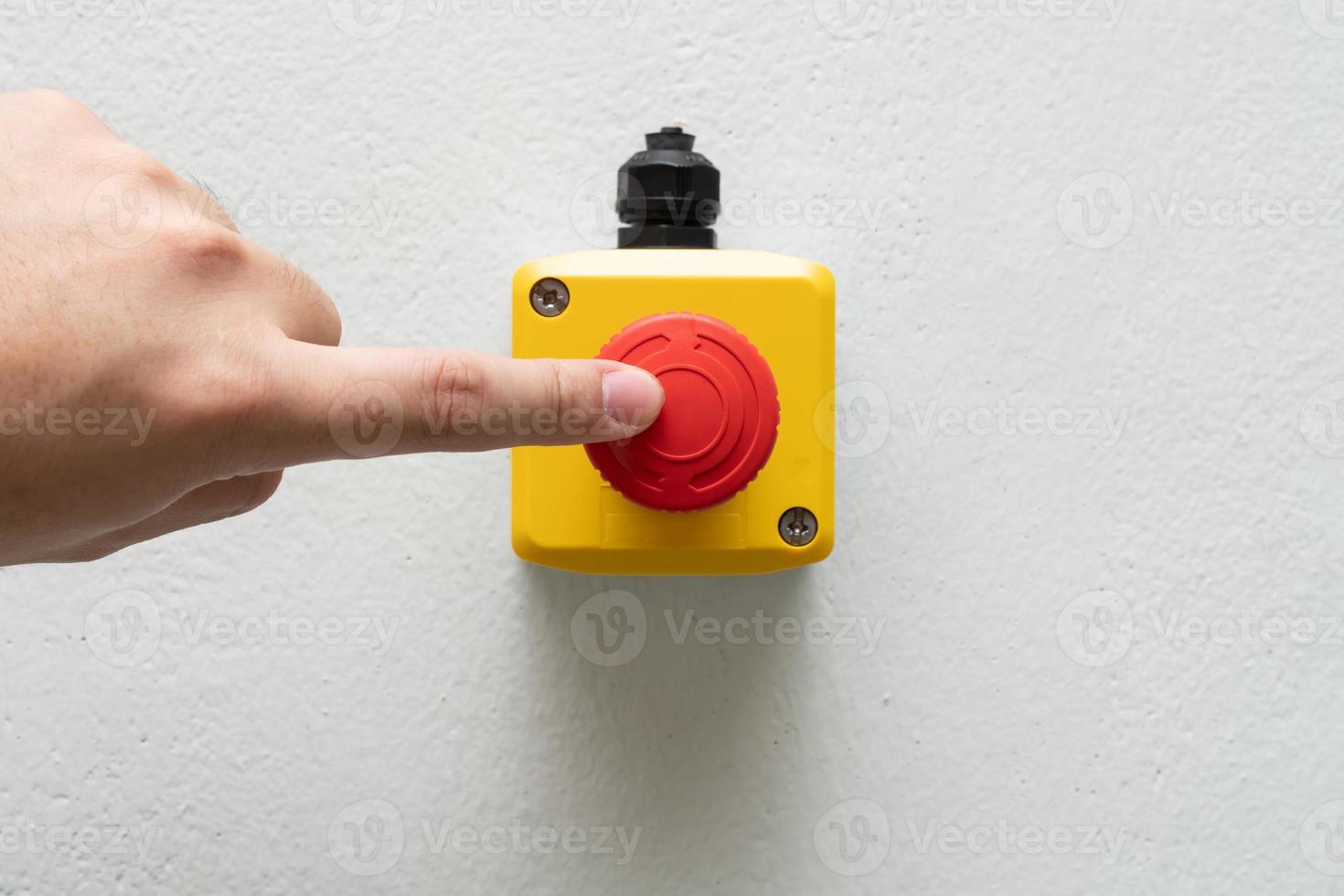 Stop Red Button and the Hand of Worker About to Press it. emergency stop button. Big Red emergency button or stop button for manual pressing. photo