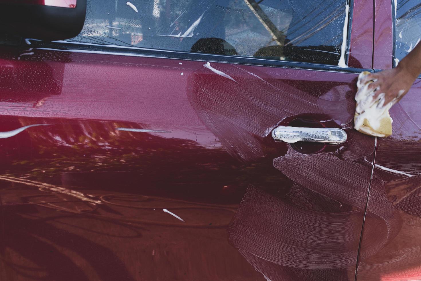 Car detailing - the man holds the microfiber in hand and polishes the car. Selective focus. photo