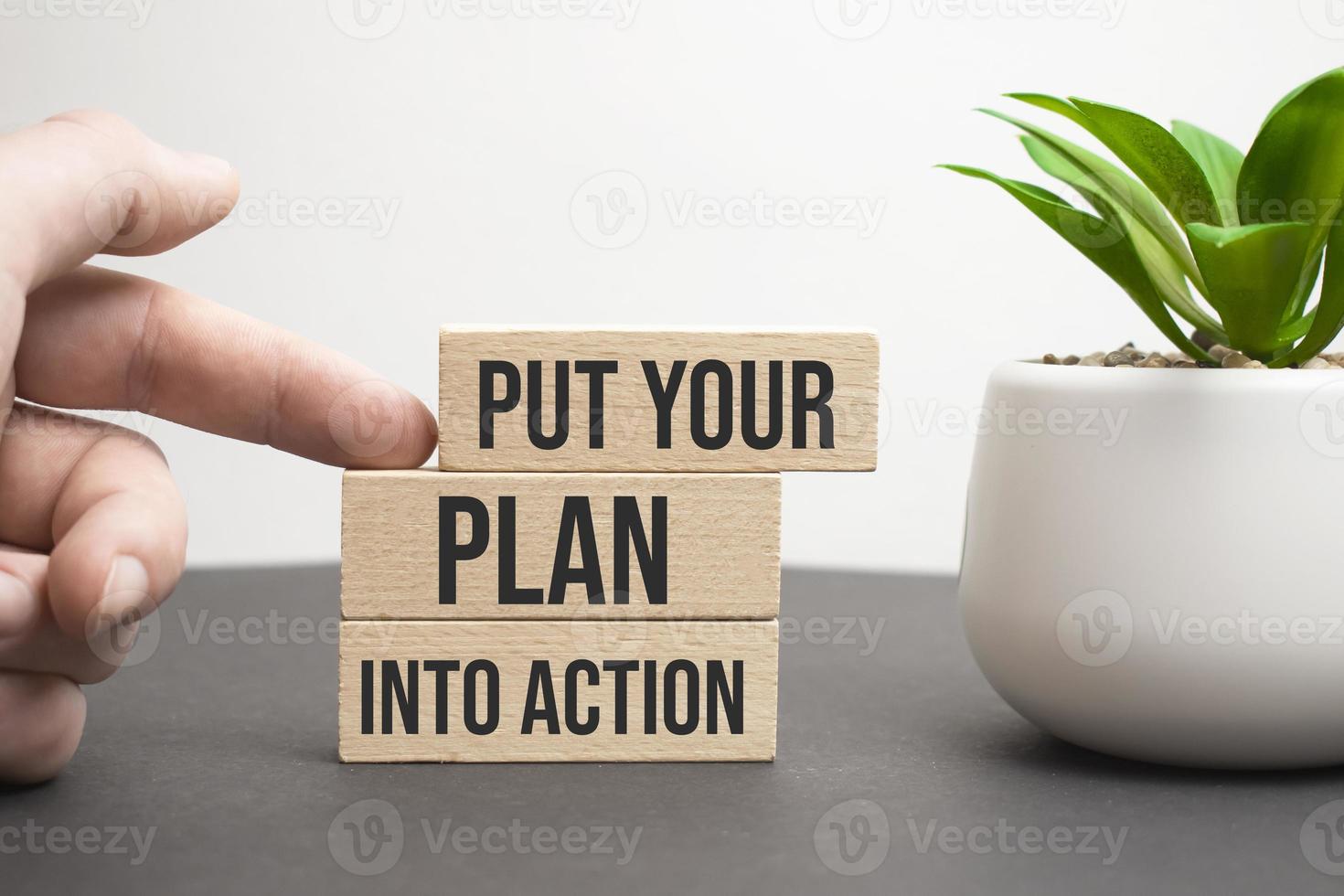 Put your plan into action symbol. Wooden blocks with words Put your plan into action. Beautiful orange background, copy space. Businessman hand. Business, plan into action concept. photo