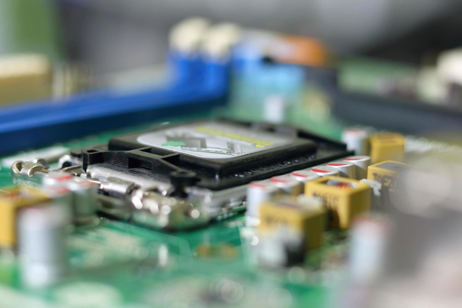 Electronic circuit boards on green background with CPU socket, selective focus photo