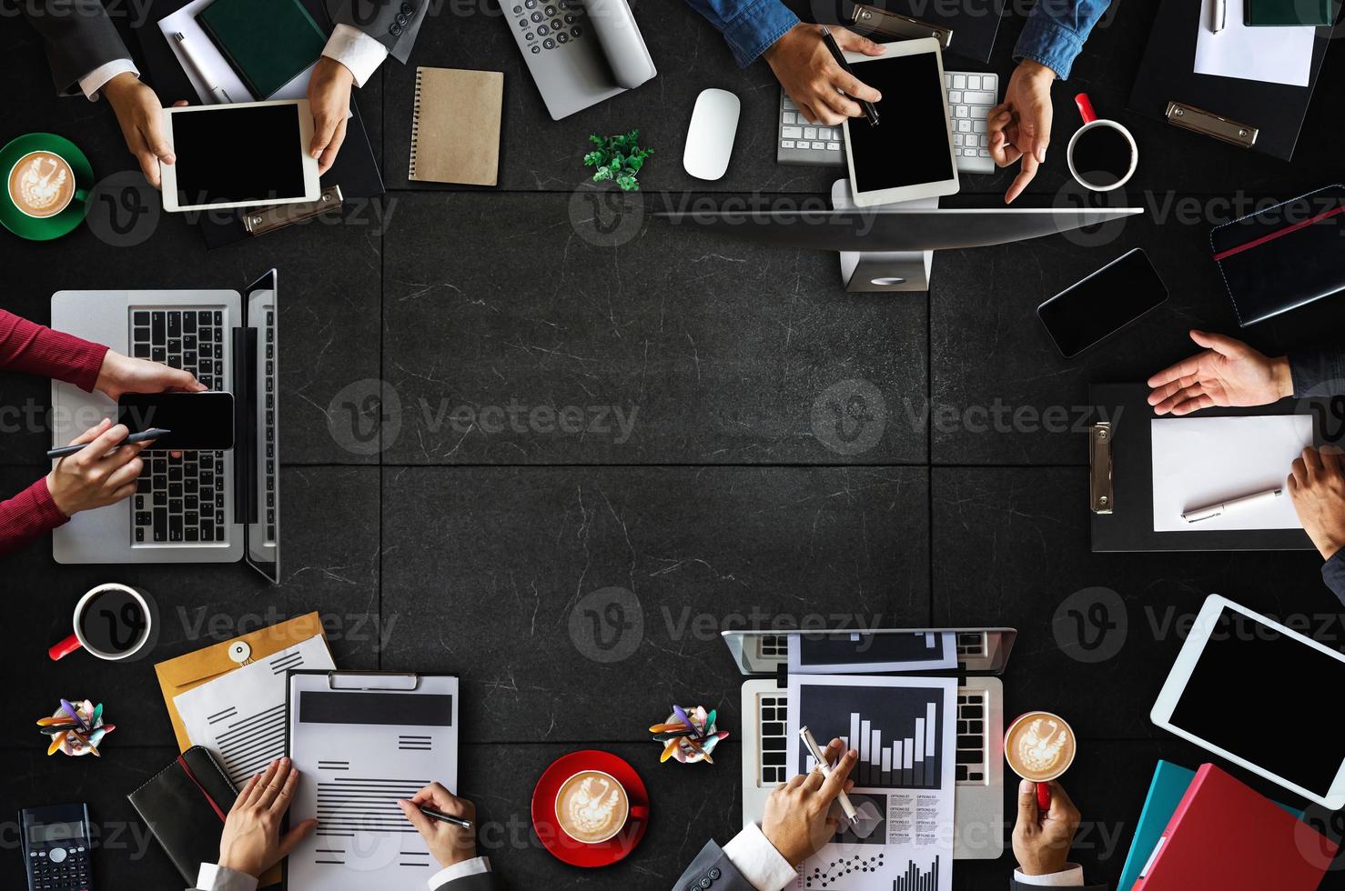 Top view of business Group of Multiethnic Busy People meeting with other in modern office with laptop computer, smartphone, tablet, coffee and document photo