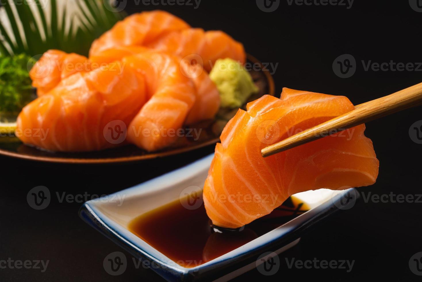 Sashimi, Salmon, Japanese food chopsticks and wasabi on the table photo