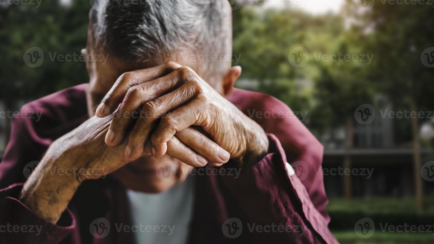 Hombre mayor que cubre su rostro con sus manos tono vintage. foto