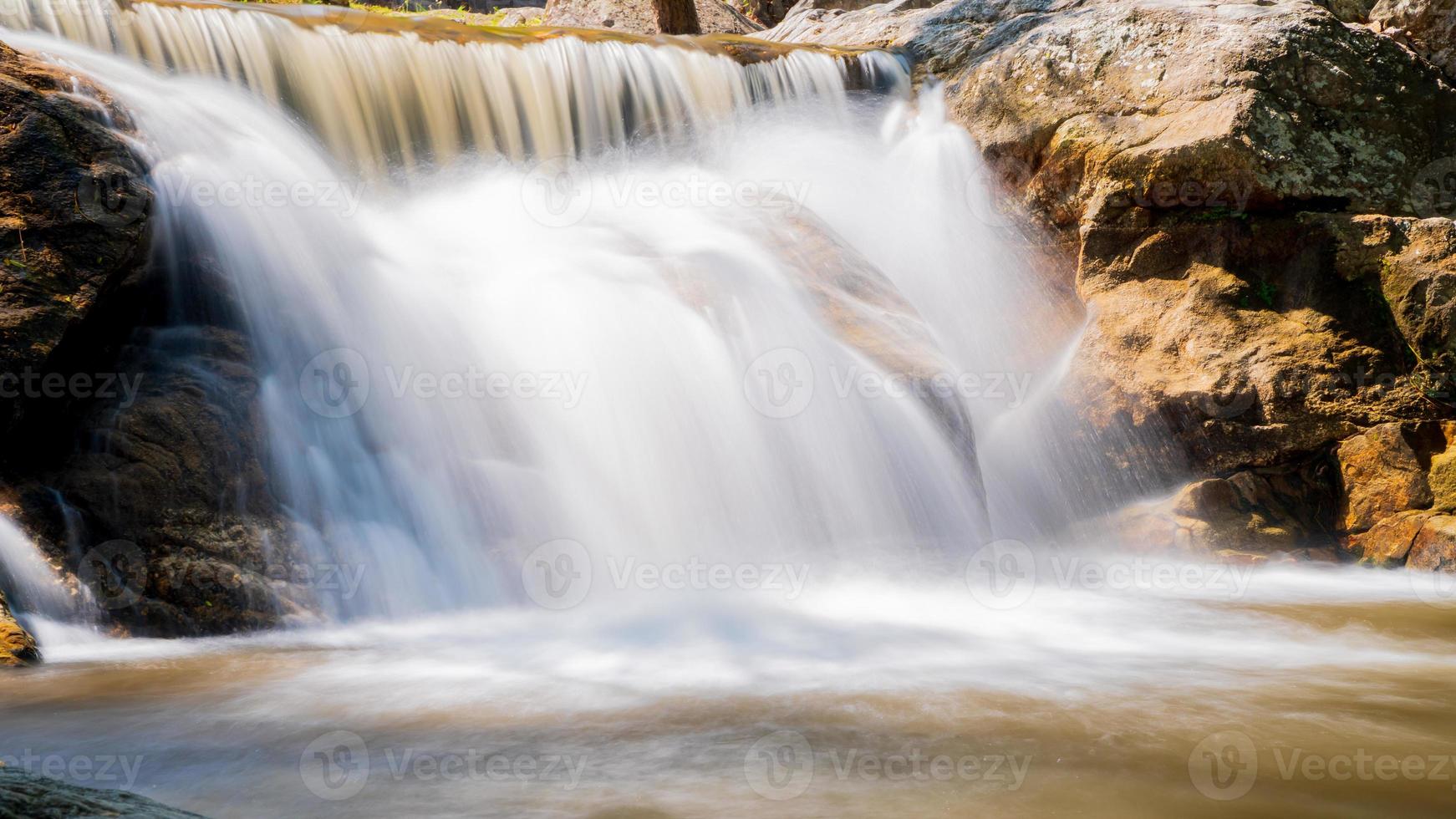 Water flowing along rocks in nature, waterfall photo