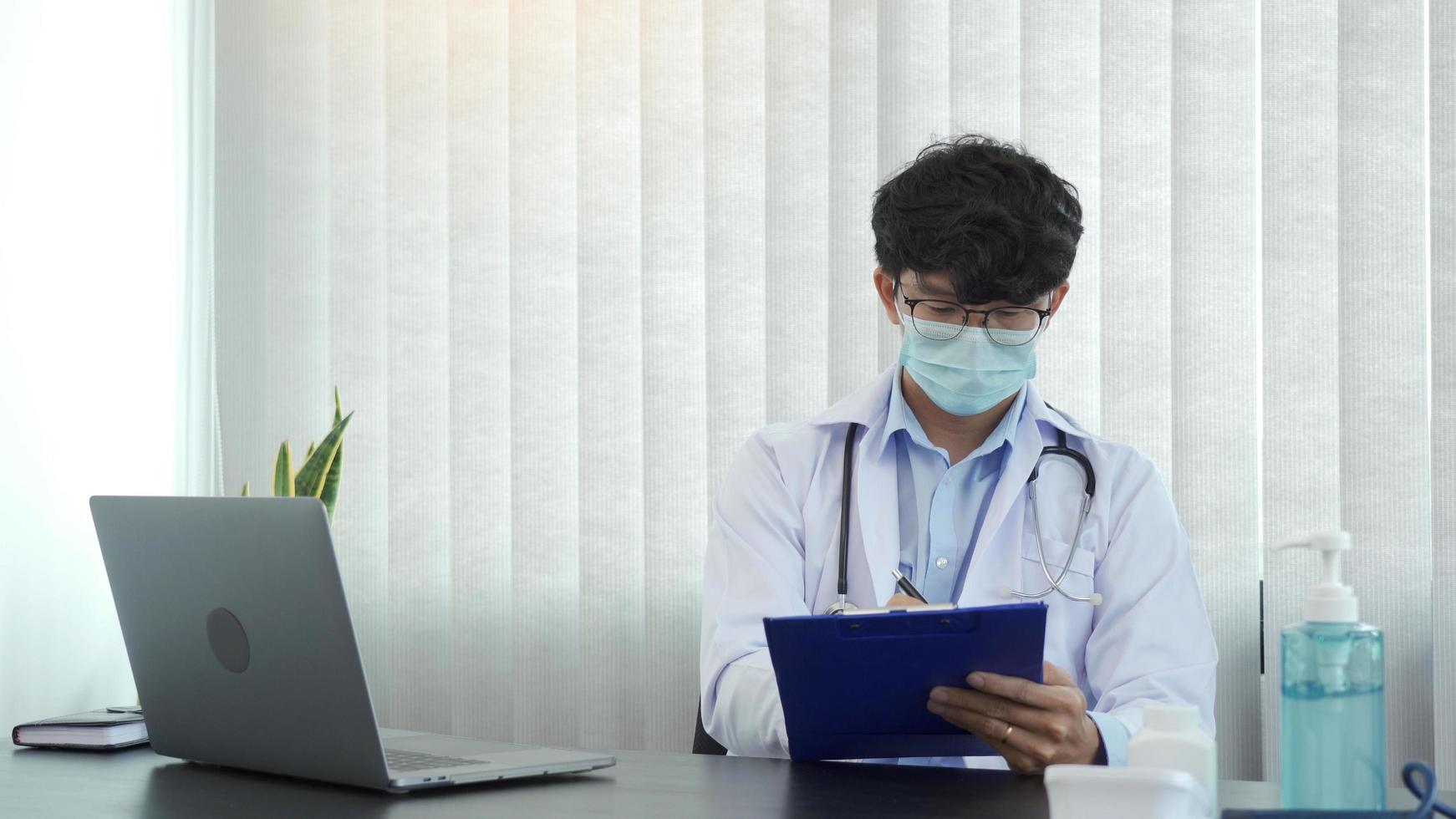 Doctor hand holding pen writing patient history list on clipboard about medication and treatment. photo