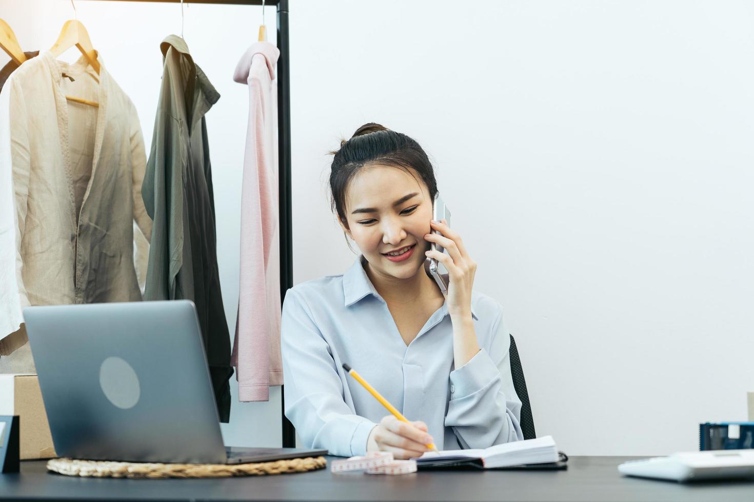 Asian entrepreneur is talking to customers over the phone about their pickup. photo