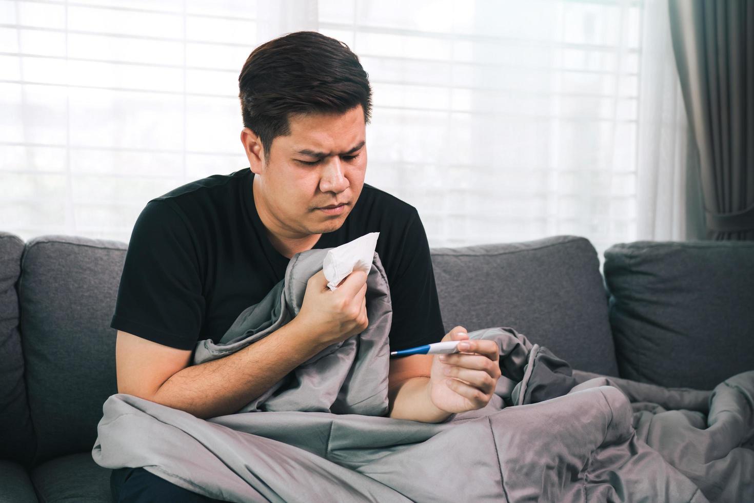 Asian people feel stressed because having cough and cold and using a thermometer to check if he has fever or illness at his home. photo