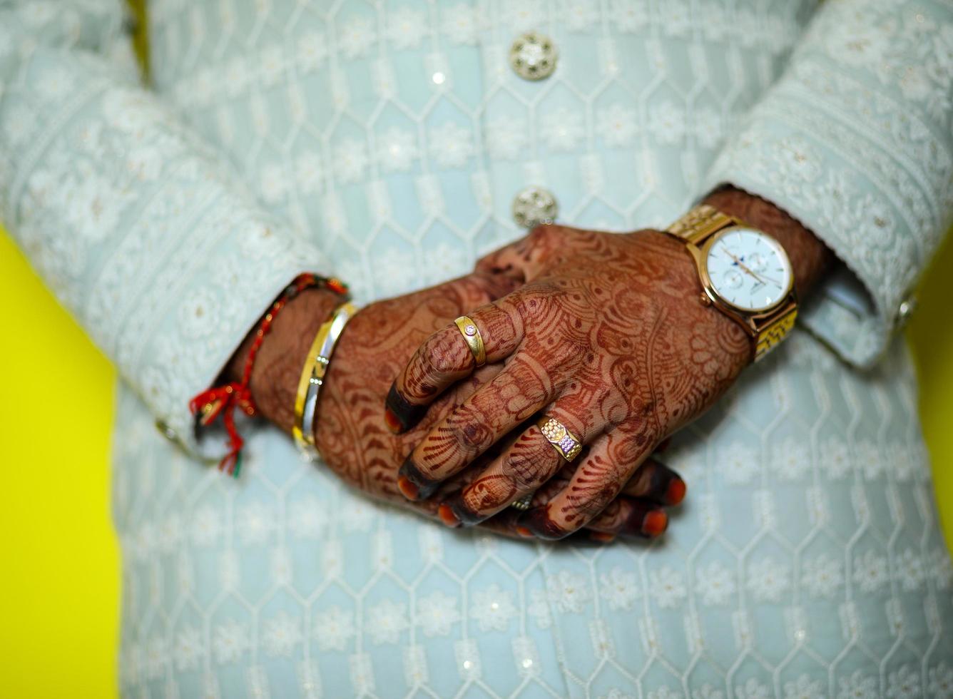 Low section of groom holding hands photo
