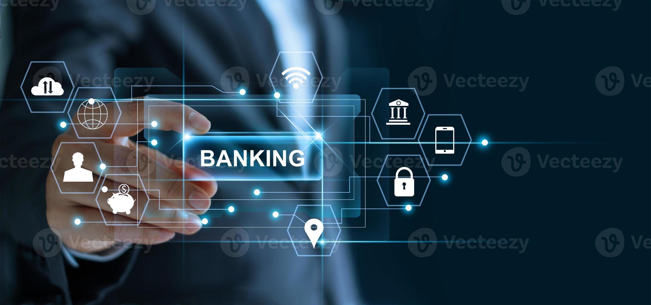 Businessman holding word banking in hand with icon network connection on virtual screen dark background photo