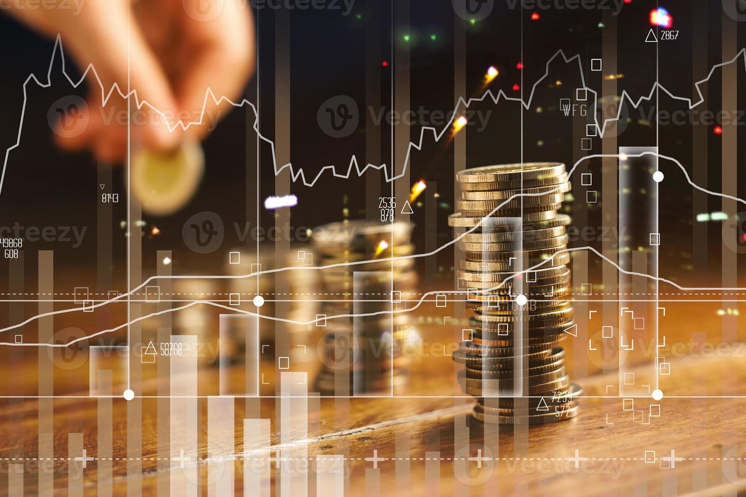 Double exposure. Hand holding golden coin of graph and rows with coins on wooden table. Finance and business concept photo
