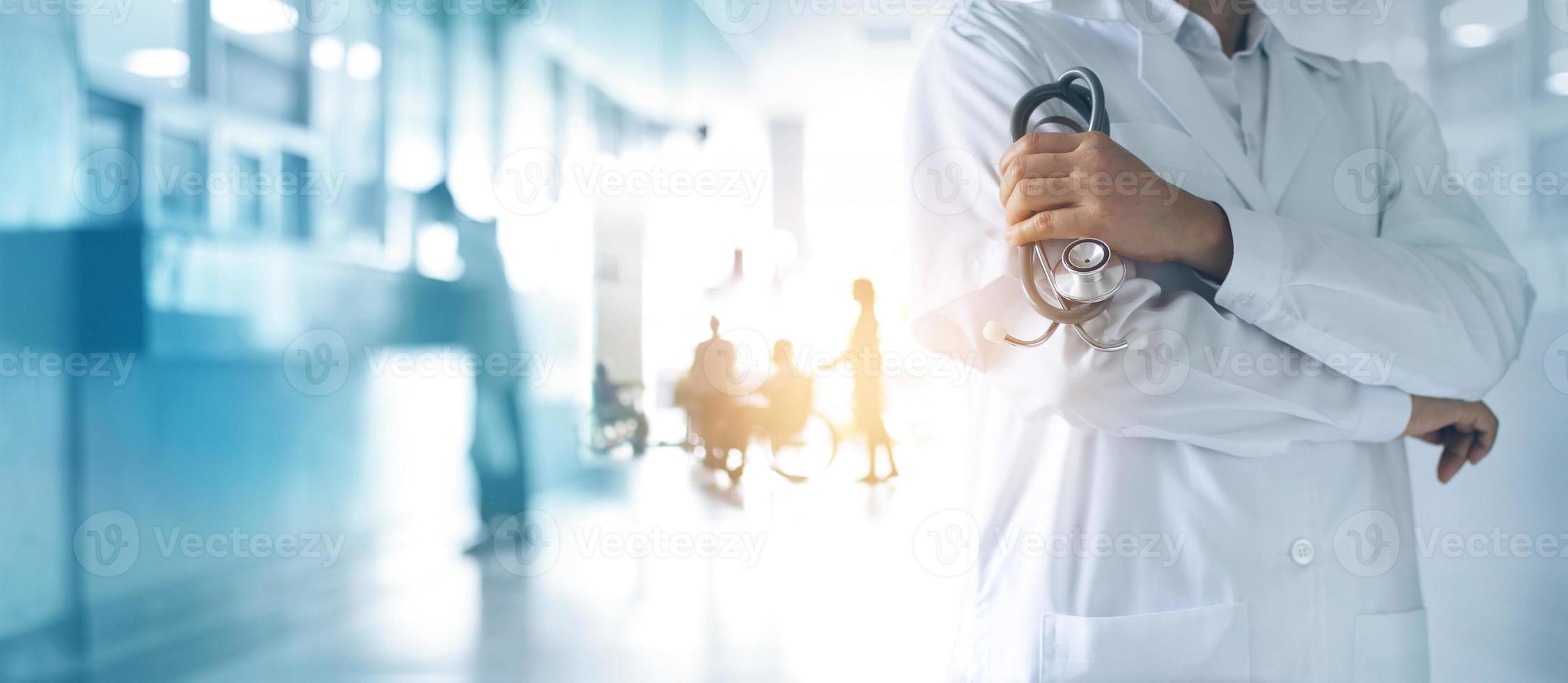 concepto médico y de salud. médico de medicina con estetoscopio en la mano y los pacientes vienen al fondo del hospital. foto