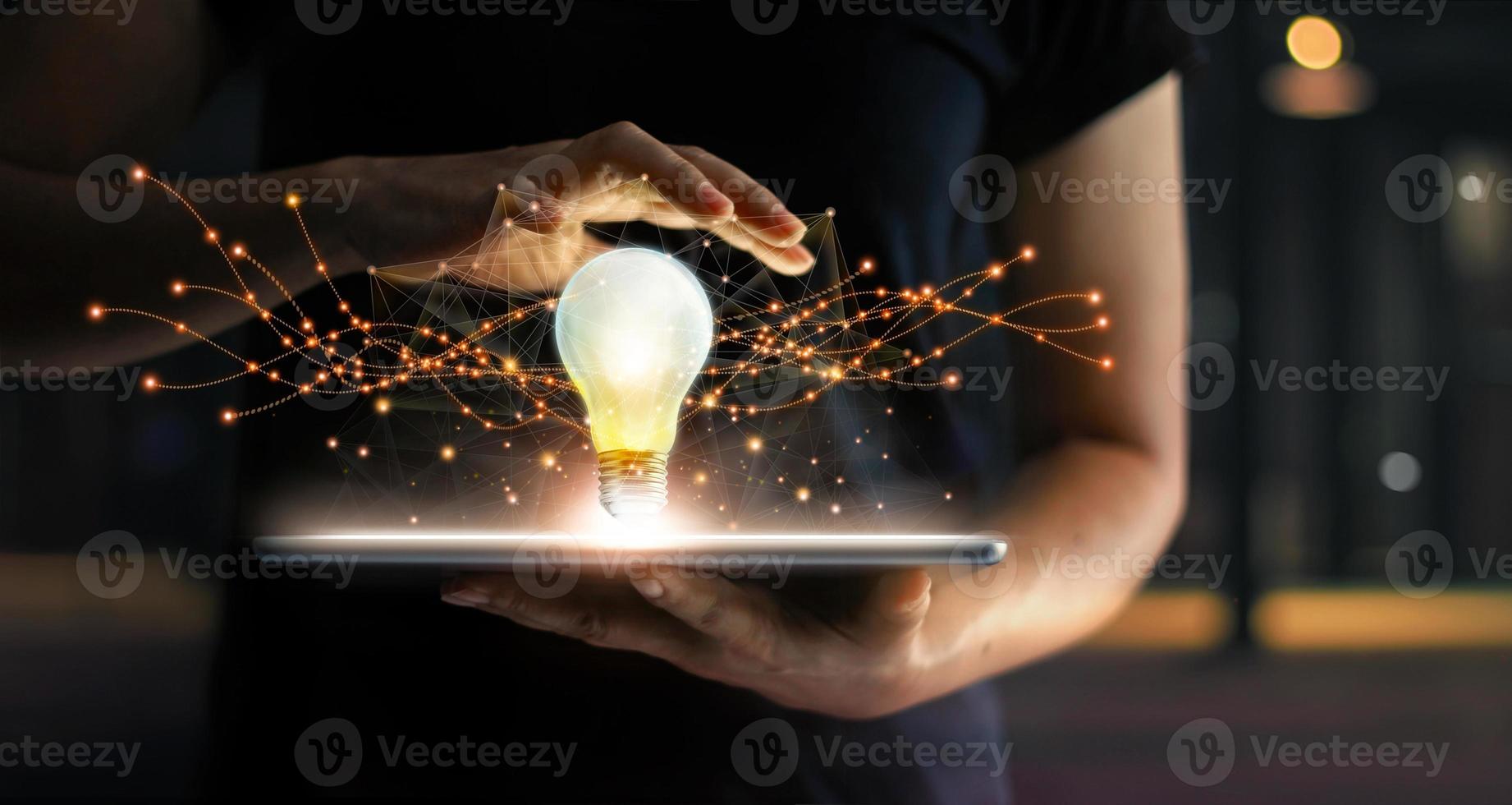 Abstract. Innovation. Hands holding tablet with light bulb future technologies and network connection on virtual interface background, innovative technology in science and communication concept photo