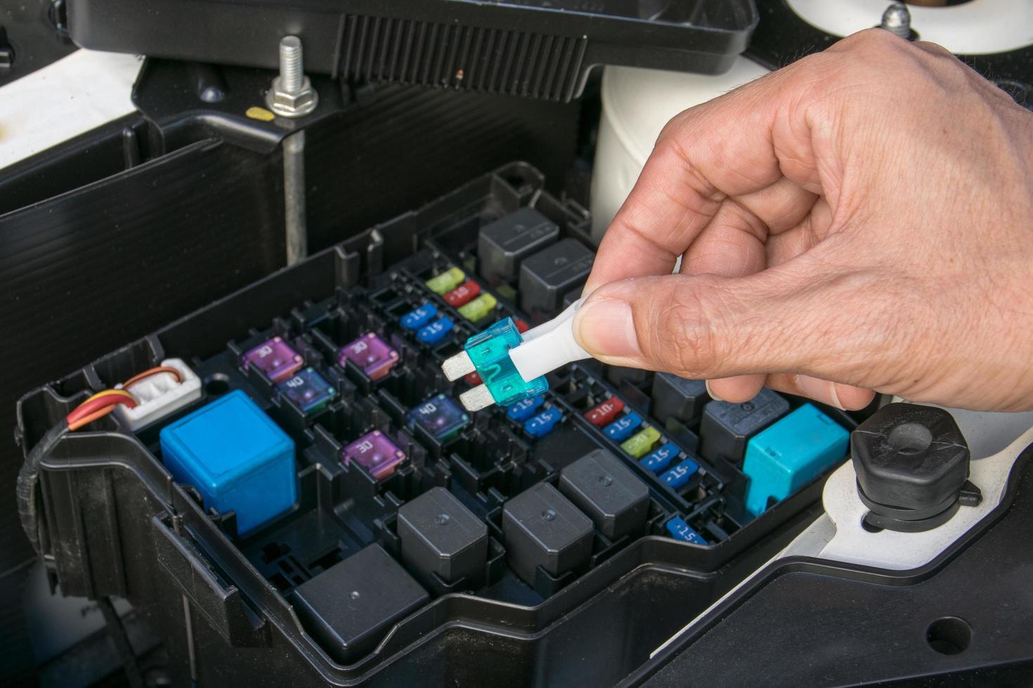 Auto mechanic checking a car fuse photo