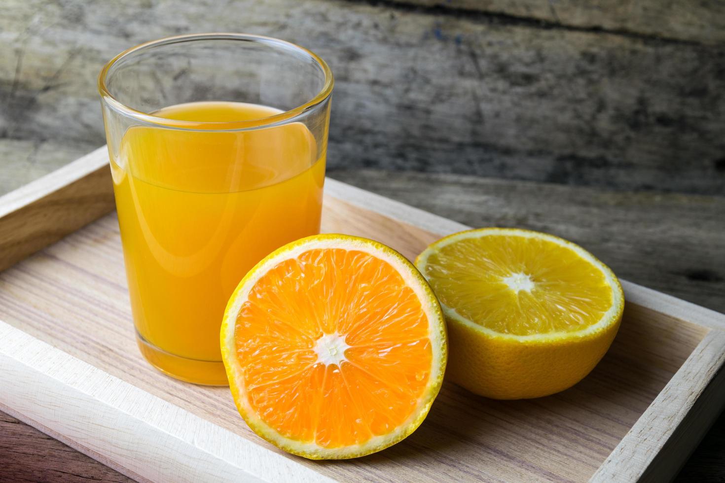 Glass of orange juice on wooden table, fresh drink photo