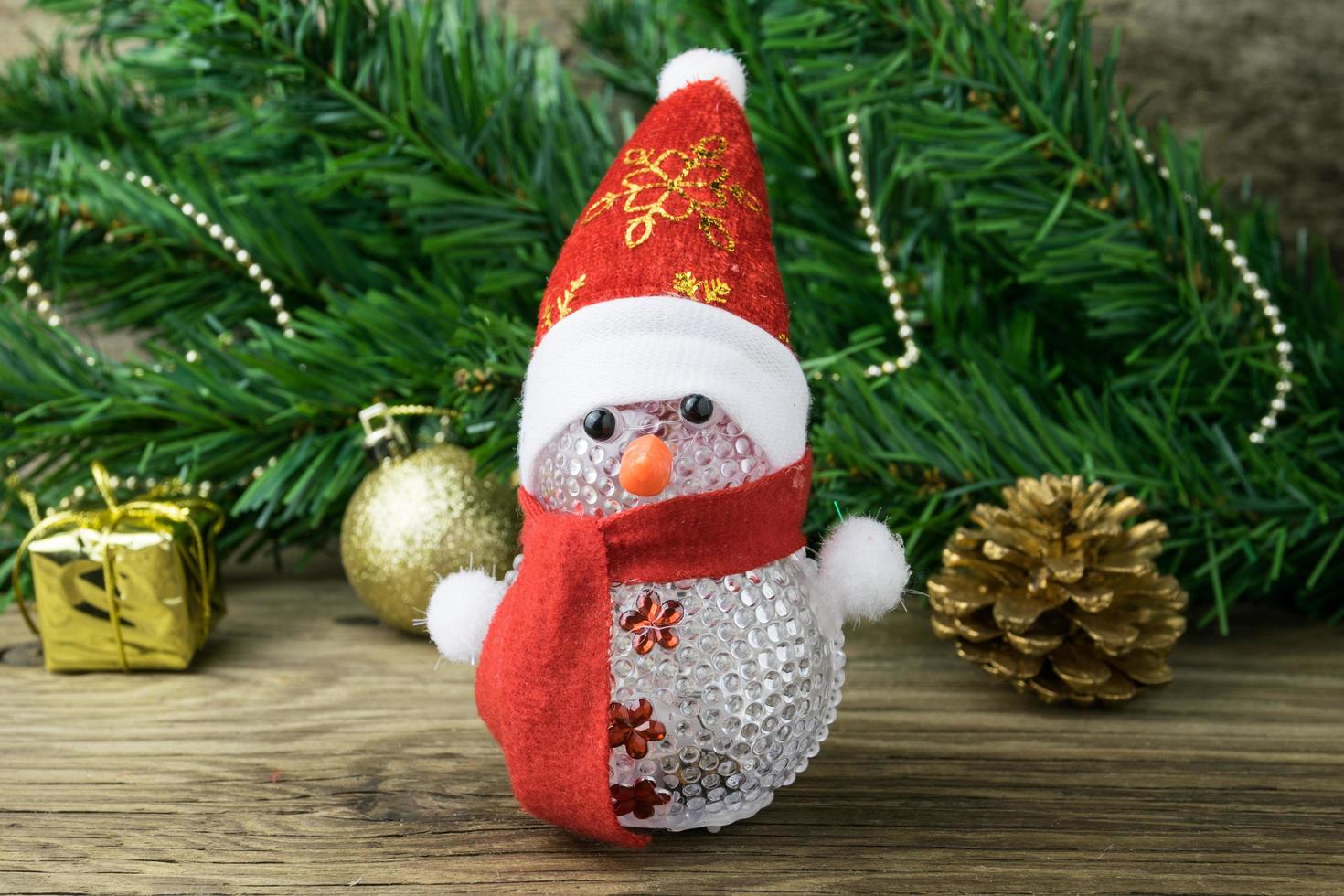 Christmas snowman toy and Christmas decorations on old wooden background. photo