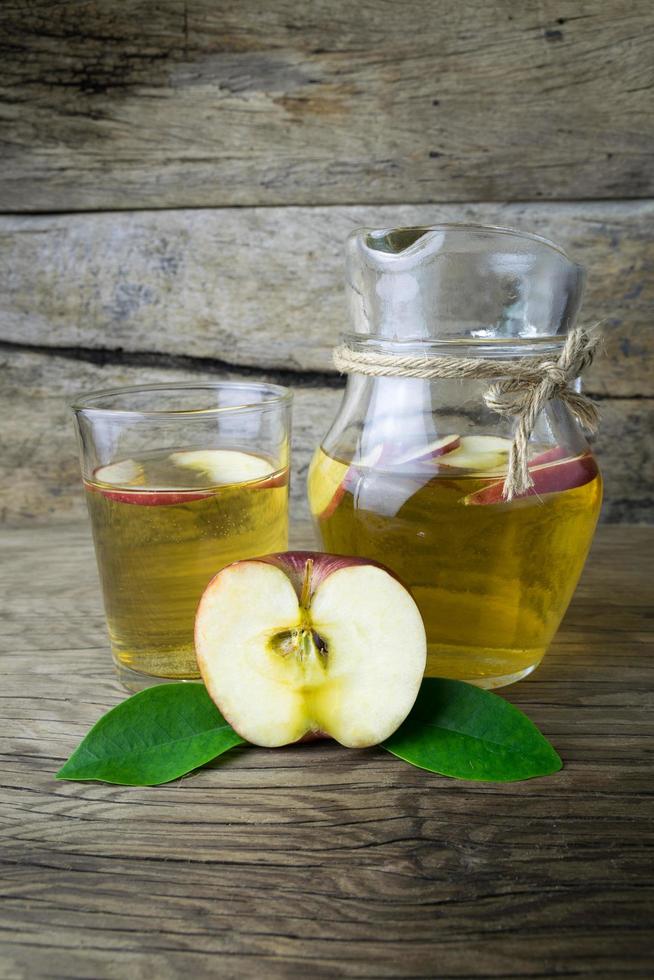 Apple juice and apples on a wooden table photo