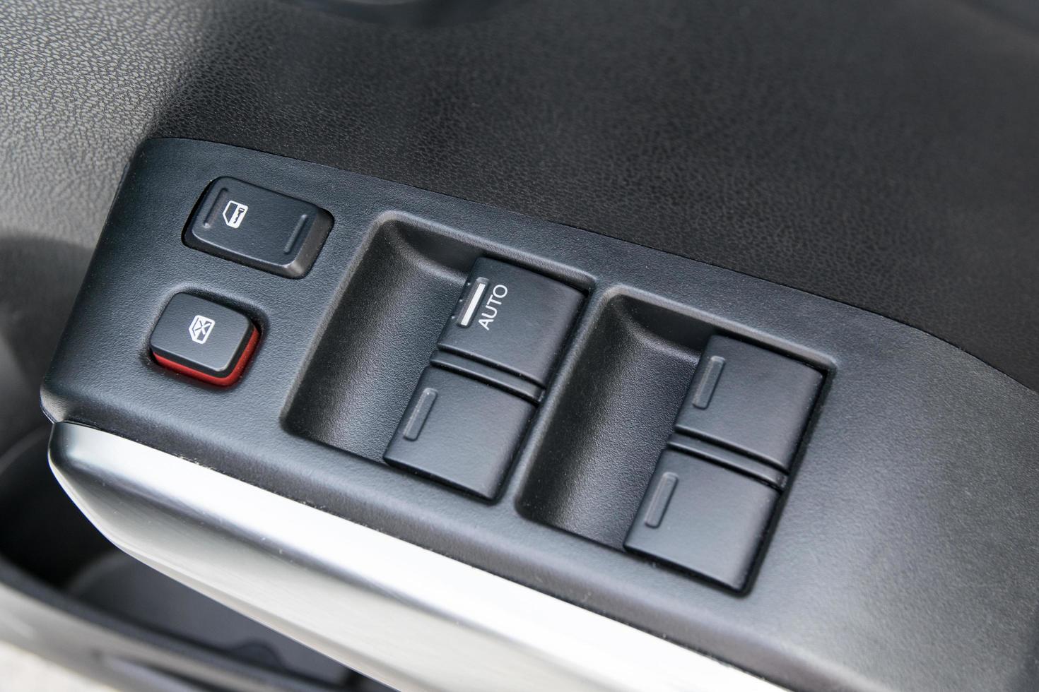 car interior details of door handle with windows controls and adjustments photo