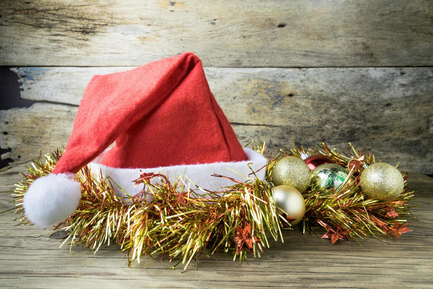 Santa Hat with Christmas decorations on old wooden background. photo