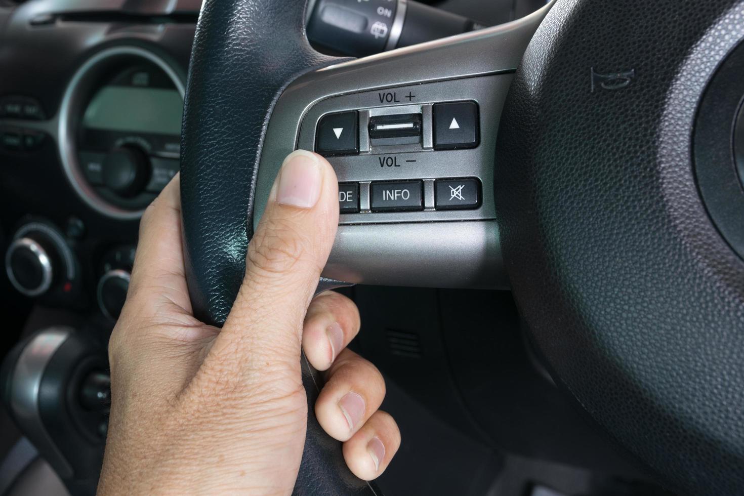 hand pushes the cruise control button on a steering photo