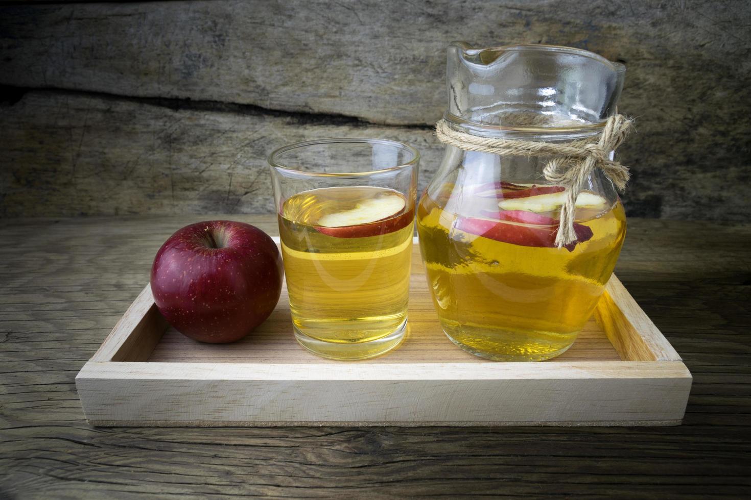 Apple juice and apples on a wooden table photo
