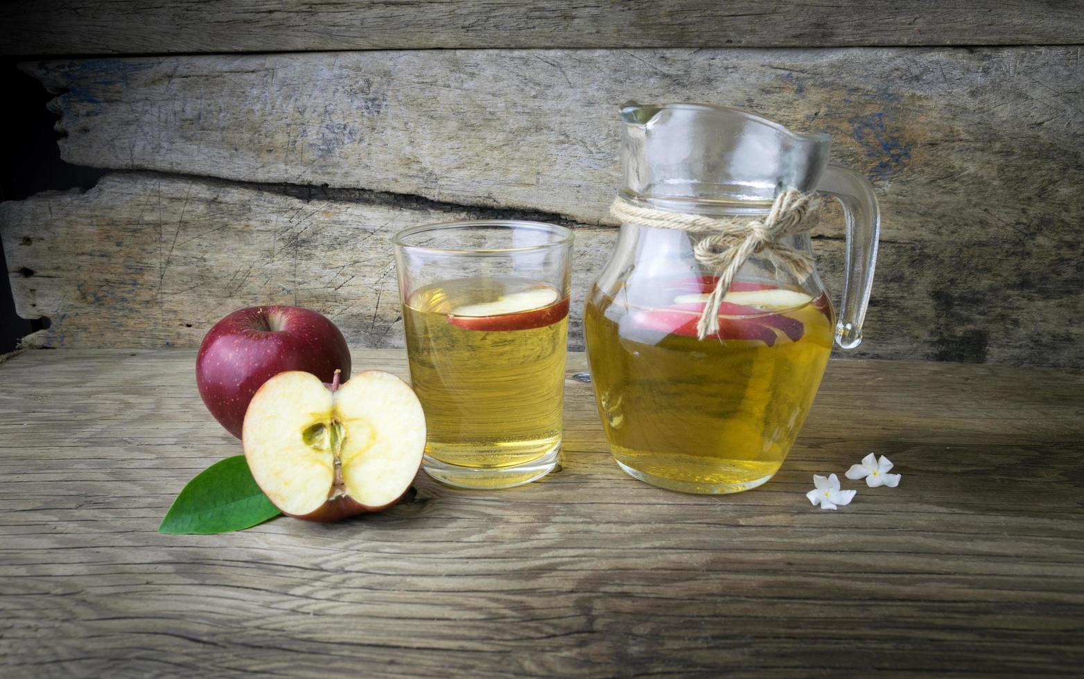 Apple juice and apples on a wooden table photo