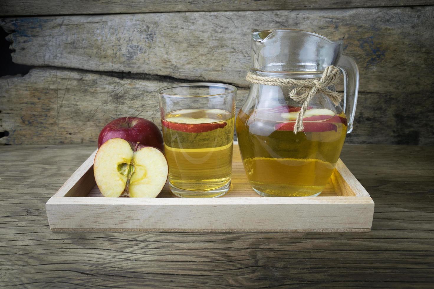 Apple juice and apples on a wooden table photo