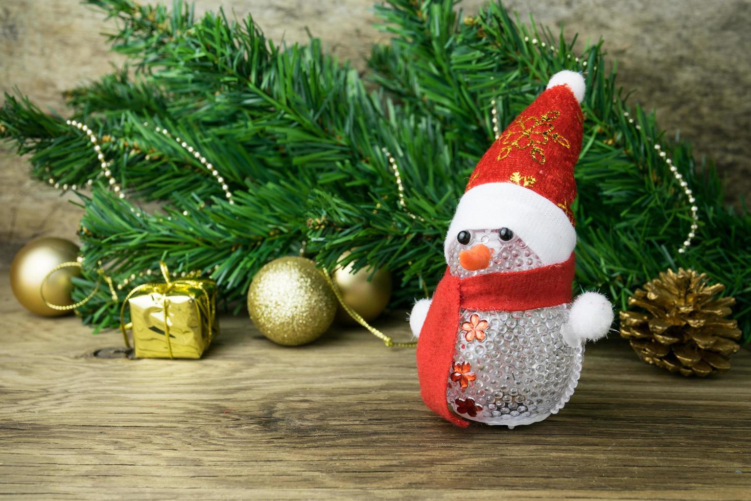 Christmas snowman toy and Christmas decorations on old wooden background. photo