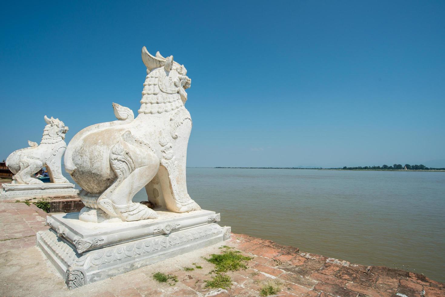 The twin Lion statue standing behind the Ayeyarwady River in Myanmar. photo