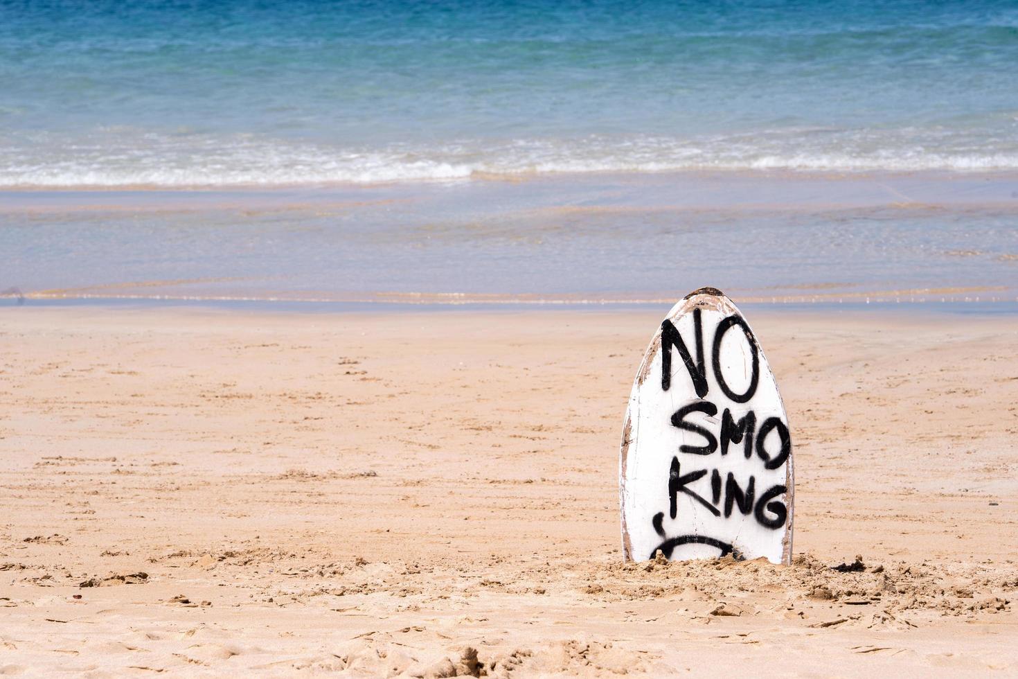 señal de advertencia de no fumar en la tabla de surf blanca en la playa en verano, concepto de diseño de protección ambiental del mar, espacio de copia, estilo de vida. foto