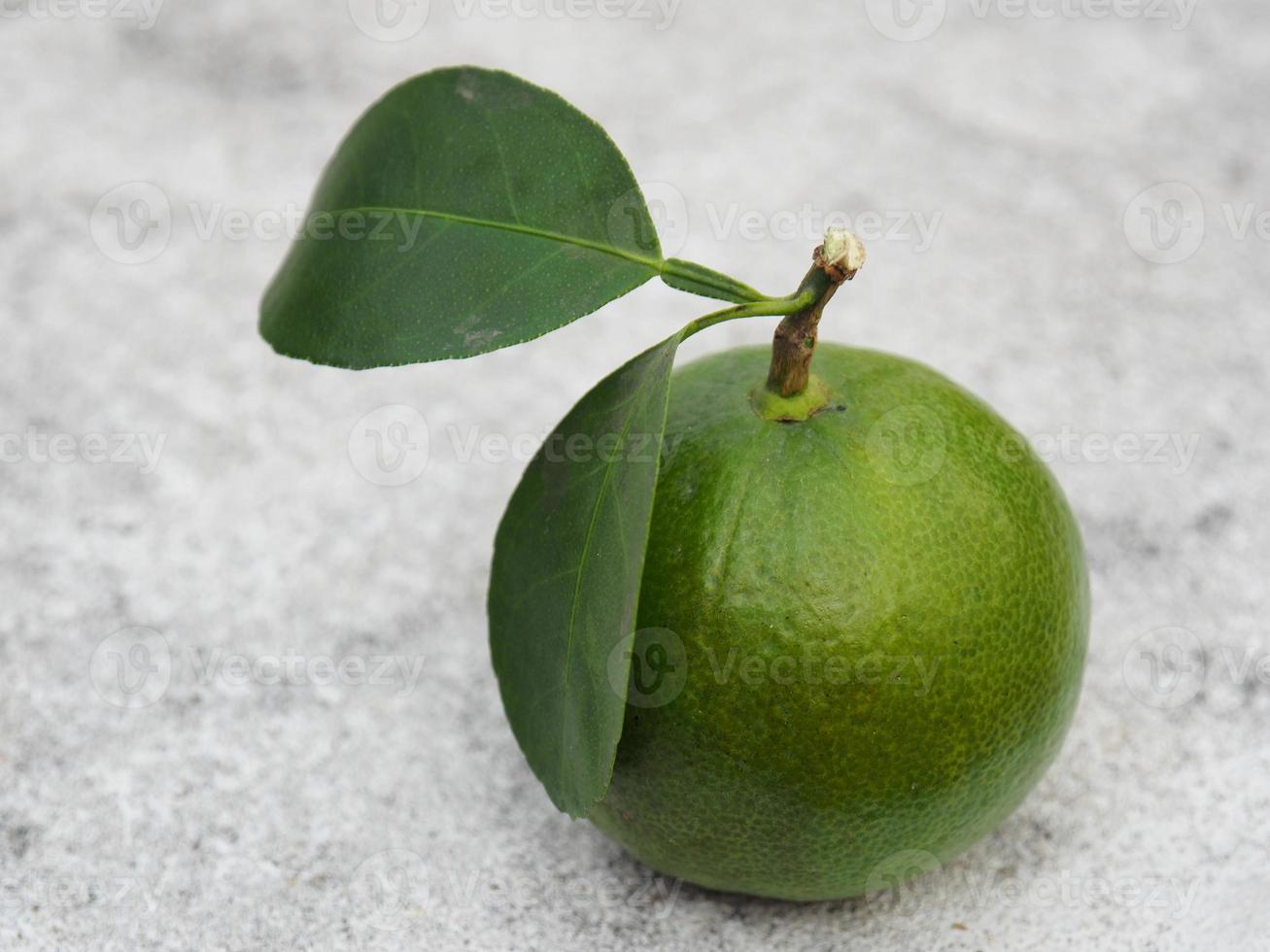 a green fresh lime with leaves on white background photo
