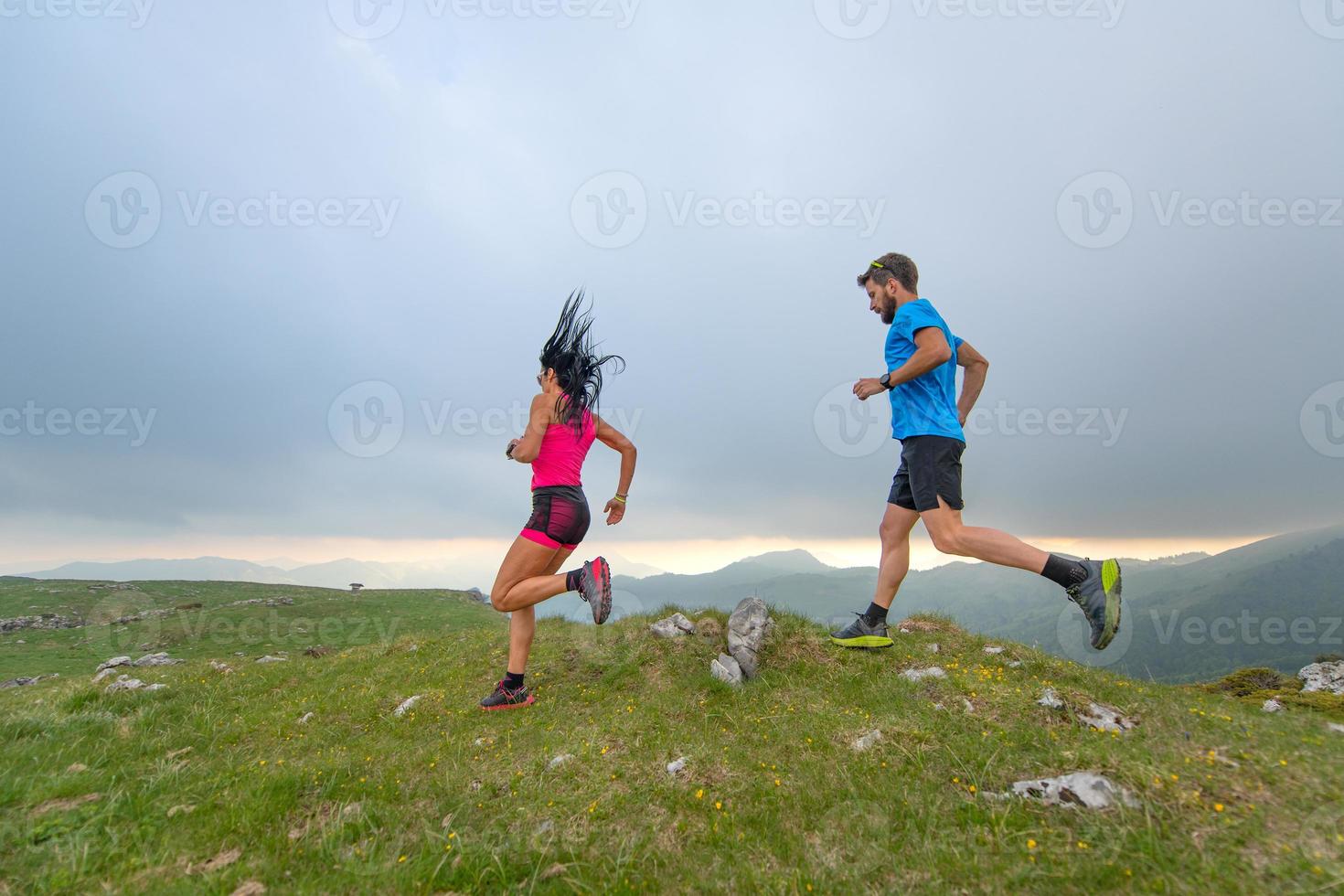 Couple of man and woman mountain athletes runners in action photo