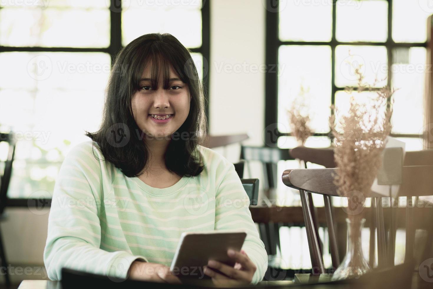 Chica gordita asiática sosteniendo tableta de computadora en la mano foto