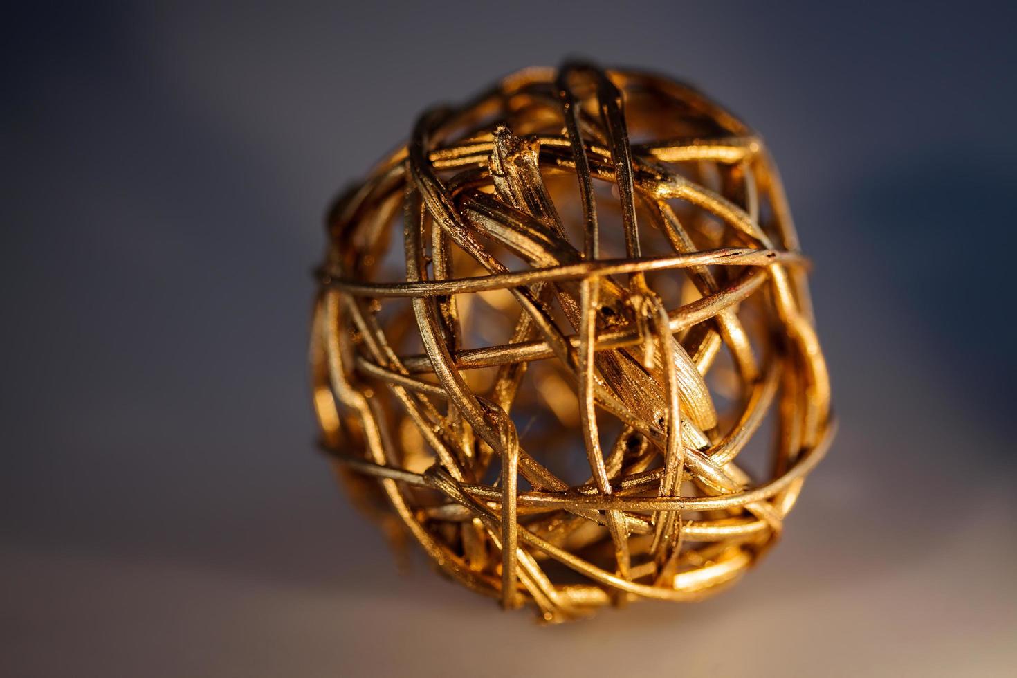 Sphere of pliable twigs painted gold to form a decorative object photo