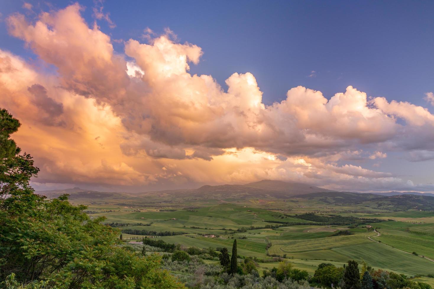 Sunset lighting up clouds over farmland near Pienza in Tuscany photo