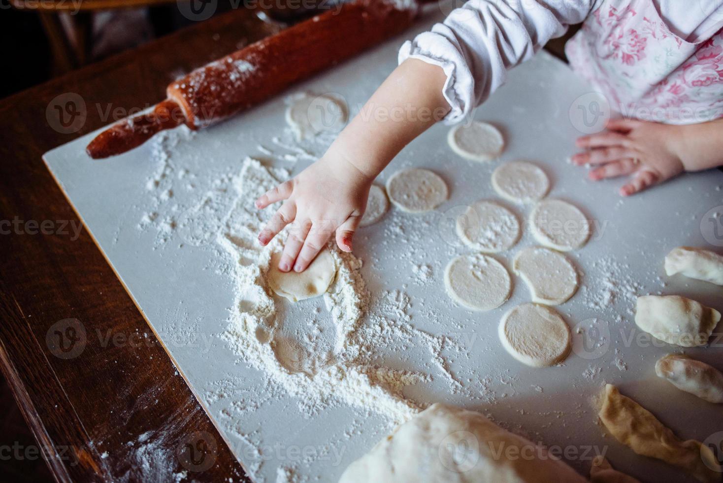 baker girl in chef hat at kitchen photo