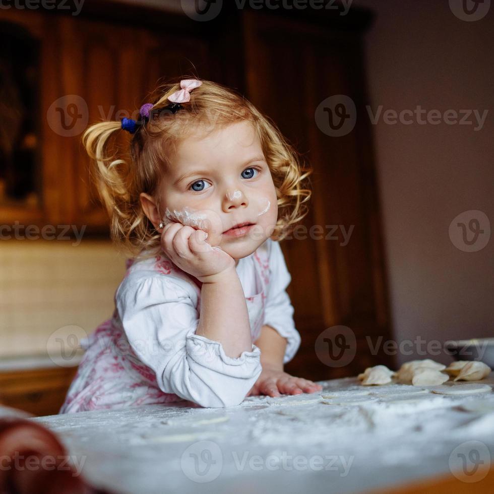 baker girl in chef hat at kitchen photo