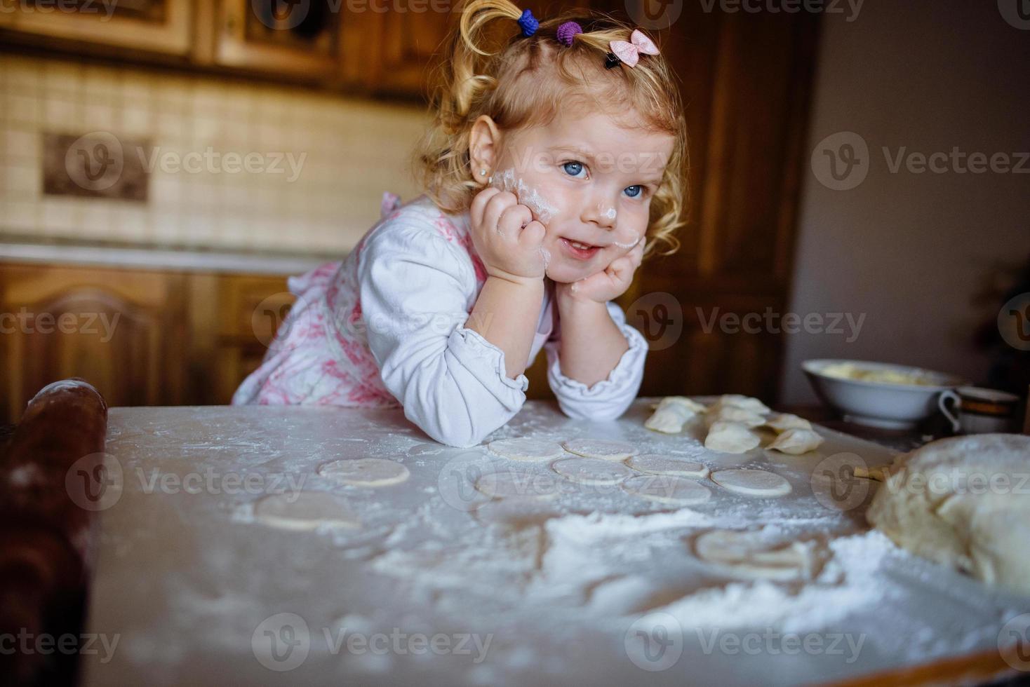 baker girl in chef hat at kitchen photo