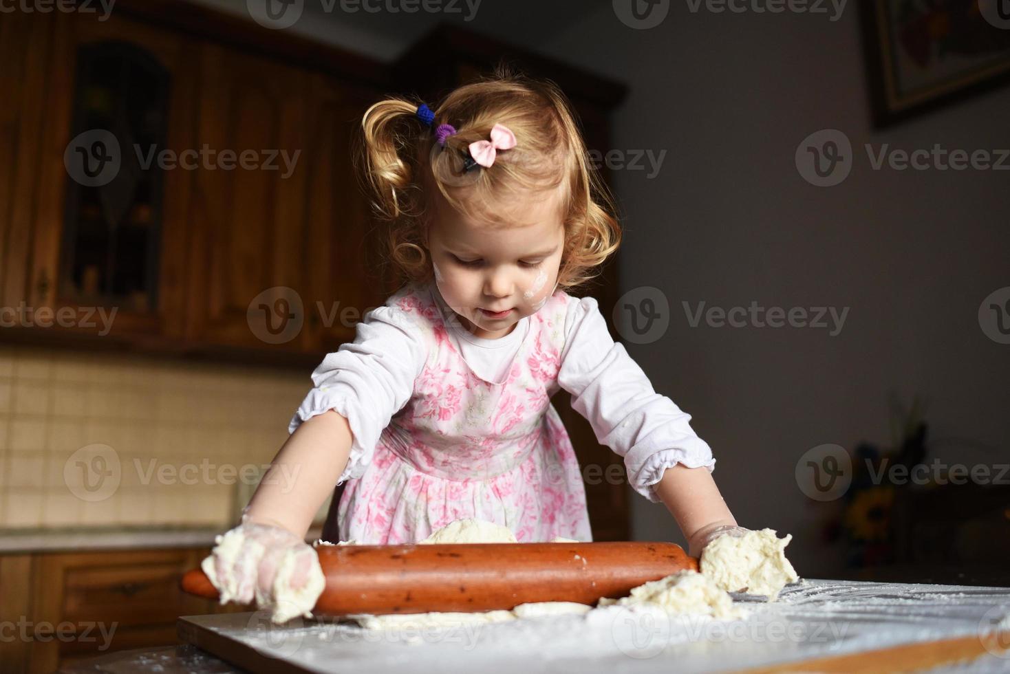 little girl kneading dough photo