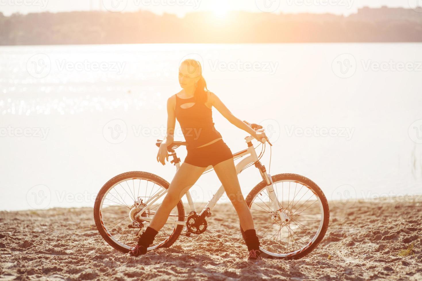 woman on a bicycle near the water photo