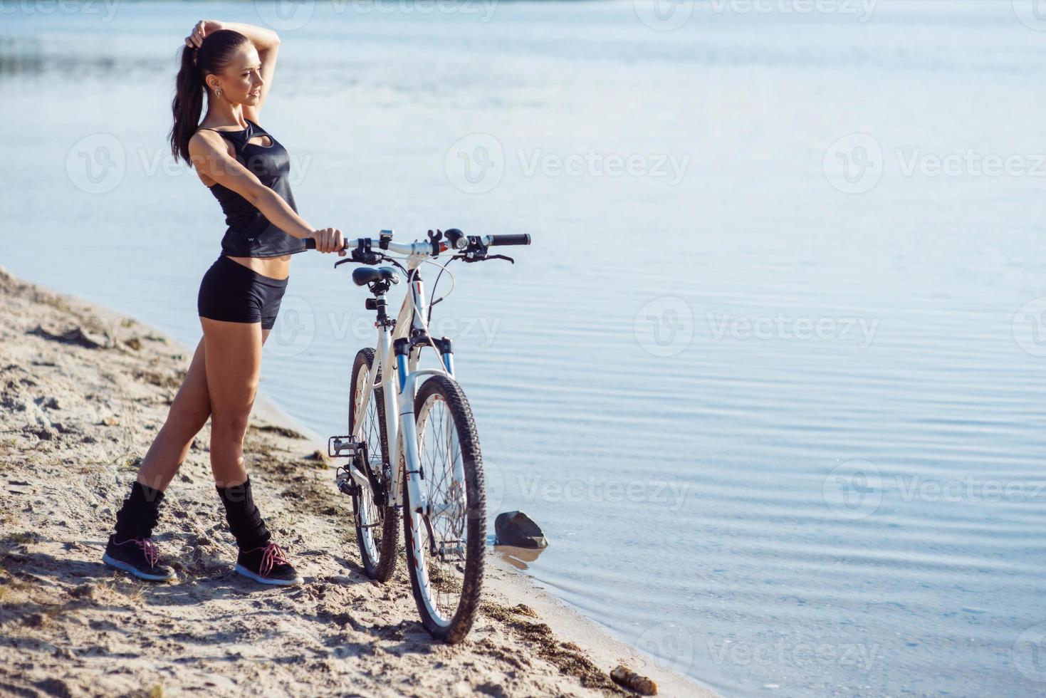 woman on a bicycle near the water photo